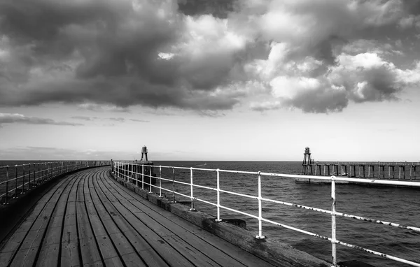 Zwart-wit beeld van Whitby pier bij de haveningang van de in Whitby in North Yorkshire, Verenigd Koninkrijk — Stockfoto