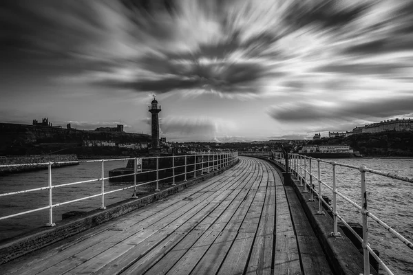 Black and white image of Whitby pier at the harbour entrance at Whitby in North Yorkshire, UK