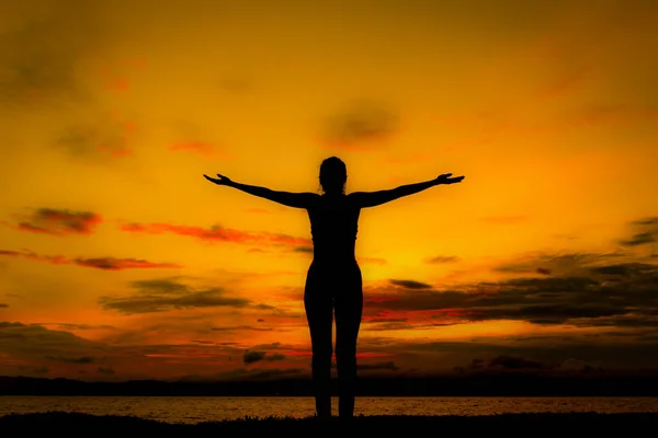 Silhouette donna felice sulla spiaggia al tramonto . — Foto Stock