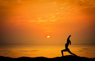 Siluet kadın oyun yoga dağ ile denize dramatik günbatımı manzara resim.