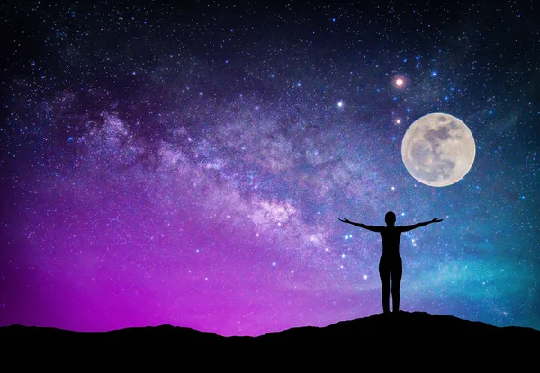 Samanyolu Gökadası ile manzara. Gece gökyüzünde yıldız, ay ve siluet mutlu kadın dağ. (Nasa tarafından döşenmiş bu ay görüntü unsurları)