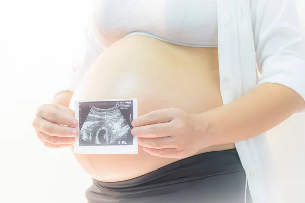 Portret van een zwangere vrouw haar buik met handen aan te raken. — Stockfoto