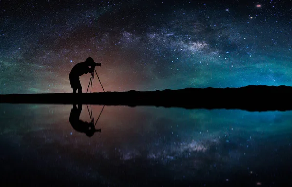 Samanyolu Gökadası ile manzara. Gece gökyüzünde yıldızlar ve siluet fotoğrafçı ile dağlarda fotoğraf çekmek.