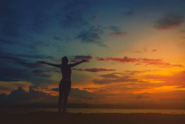 Gün batımında sahilde siluet mutlu kadınla. Vintage sesi