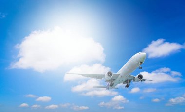 Mavi gökyüzü ile bulut arka plan üzerinde uçan uçak.