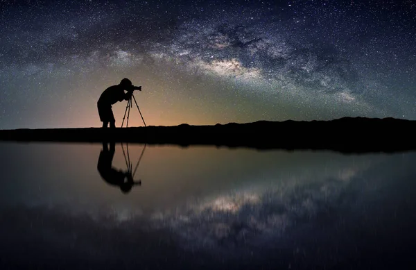 Krajobraz z Mlecznej. Nocne niebo z gwiazdami i sylwetka fotograf zrobić zdjęcie na górze. — Zdjęcie stockowe