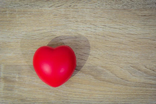 Coeur rouge sur fond de table en bois . — Photo