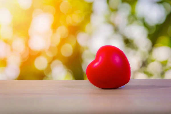 Coeur rouge sur table en bois avec fond clair bokeh . — Photo