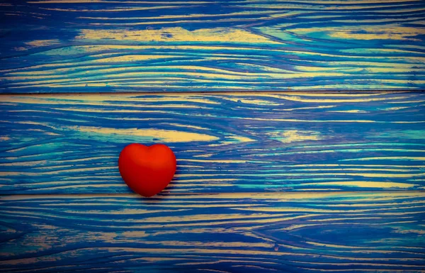 Rood hart op blauwe houten tafel achtergrond. Vintage Toon — Stockfoto