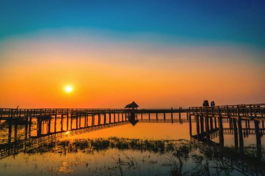 Siluet eski ahşap köprü ve günbatımı gölde Pavyonu. Vintage sesi