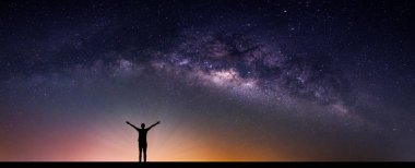 Samanyolu Gökadası ile manzara. Gece gökyüzünde yıldızlar ve dağ siluet mutlu adam. Uzun pozlama fotoğraf.