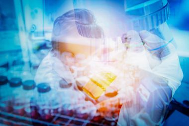 Test tüpü bilim adamı el ve kadın bilim adamı Biyoloji Laboratuvarı bir test yapıyor. Çift pozlama