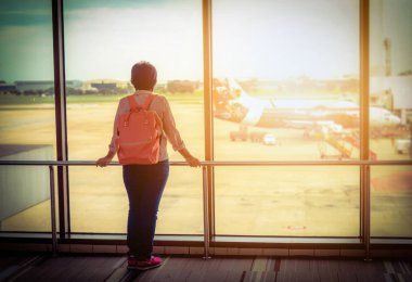 Genç Asyalı kız havaalanında seyahat sırt çantası ile. Vintage sesi