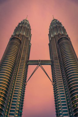 Kuala Lumpur, Malezya - 29 Temmuz 2017. Petronas ikiz kuleleri gökdelen üzerinde 29 Temmuz 2017 gün batımında. 1998'den 2004 için dünyadaki en yüksek binalar ve dünyanın en yüksek İkiz Kuleler kalır. Binalar Kuala Lumpur bir dönüm noktası vardır
