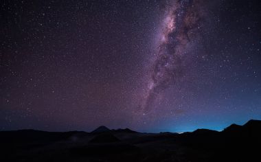 Samanyolu Gökadası ile Mount Bromo yanardağ (Gunung Bromo) Bromo Tengger Semeru Milli Parkı'nda, Doğu Java, Endonezya üzerinden manzara. Gece gökyüzünde yıldızlar ile. Uzun pozlama fotoğraf.