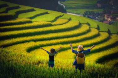 Kadın çiftçi ve pirinç tarlaları de Mu Cang Chai, Yenbai, Vietnam gün batımında teraslı kolunda yükselterek kızı.