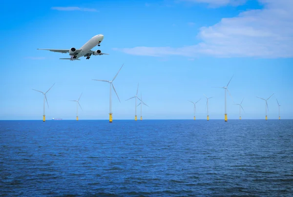 Offshore Wind Turbine with plane fly in a Wind farm under construction off coast of England. — Stock Photo, Image