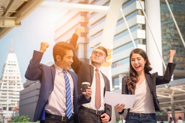 Portrait of Business team raising arms celebrate on blurred city background. Business success concept.