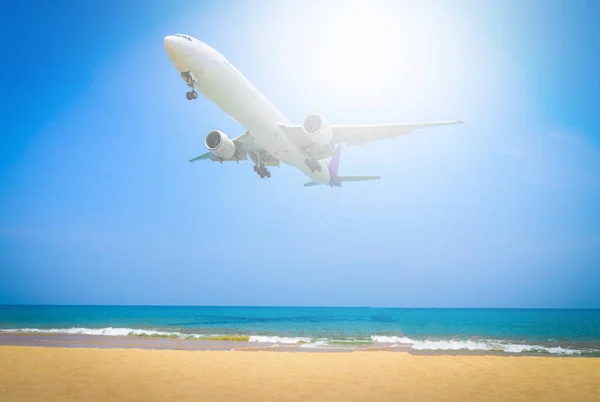 Avión volando en el cielo azul con fondo de nubes con la playa en el día de verano . — Foto de Stock