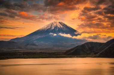 Mt. Dağın manzara resmi. Fuji, Japonya 'nın Yamanashi şehrinde sonbahar yaprakları ile Motosu Gölü üzerinde..
