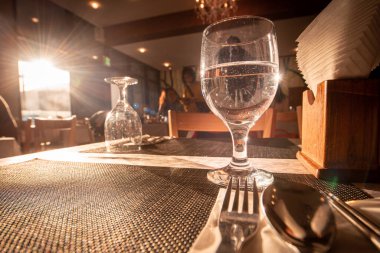 Lüks masada yemek için bir bardak su. Seçici odaklanma. Sıcak ton.