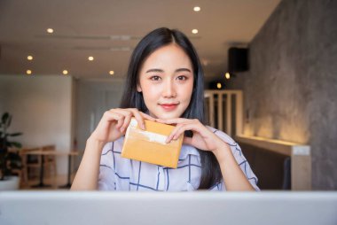 Genç Asyalı 'nın portresi evde dizüstü bilgisayarla online alışveriş yapıyor. Çevrimiçi satış ve dağıtım kavramı