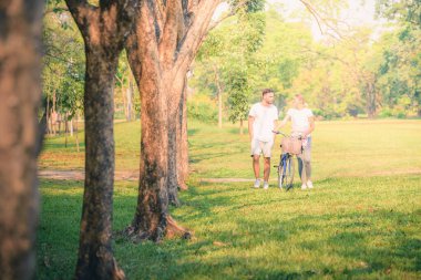 Gün batımında parkta eğlenen genç bir çiftin portresi. Romantik ve aşk kavramını. Sıcak ton.