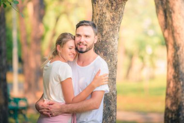 Gün batımında parkta eğlenen genç bir çiftin portresi. Romantik ve aşk kavramını. Sıcak ton.