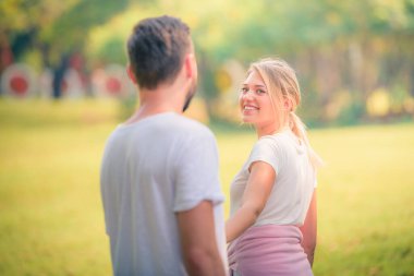 Gün batımında parkta eğlenen genç bir çiftin portresi. Romantik ve aşk kavramını. Sıcak ton.