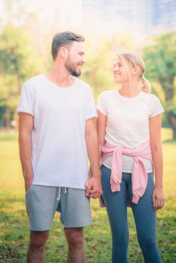 Gün batımında parkta eğlenen genç bir çiftin portresi. Romantik ve aşk kavramını. Sıcak ton.