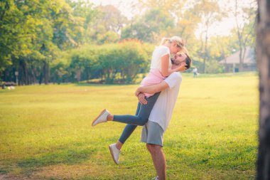 Gün batımında parkta eğlenen genç bir çiftin portresi. Romantik ve aşk kavramını. Sıcak ton.