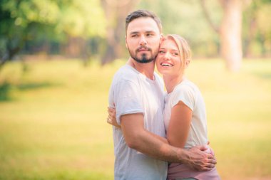 Gün batımında parkta eğlenen genç bir çiftin portresi. Romantik ve aşk kavramını. Sıcak ton.