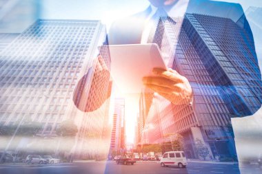 Şehirdeki bulanık arka planda dijital tablet kullanan iş adamının çifte pozlama görüntüsü. İş başarısı konsepti.