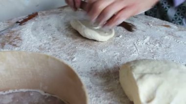 Kadınların elleri hamuru yoğurur.