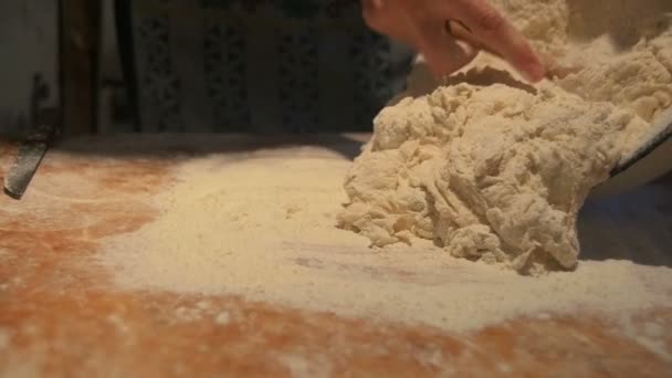 Mains pétrissant la pâte dans la farine sur la table — Video