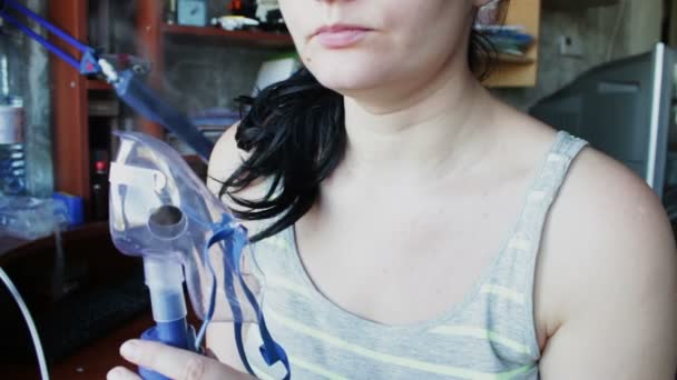 Chica está respirando un vapor a través de un inhalador pacientemente — Vídeos de Stock
