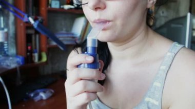 Kız bir buhar yoluyla bir Inhaler sabırla nefes alıyor