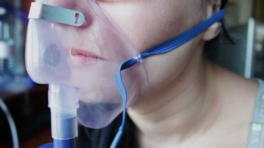 Kız bir buhar yoluyla bir Inhaler sabırla nefes alıyor