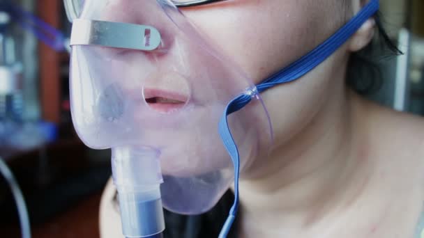 女の子は辛抱強く、吸入器を介して蒸気を呼吸します。 — ストック動画