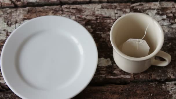 Marshmallows e uma xícara branca com chá preto — Vídeo de Stock