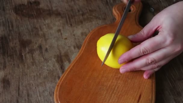 Hand in Scheiben geschnittene Zitrone auf Schneidebrett Nahaufnahme — Stockvideo