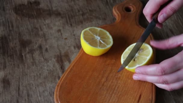 Limón rebanado a mano en el primer plano de la tabla de cortar — Vídeo de stock