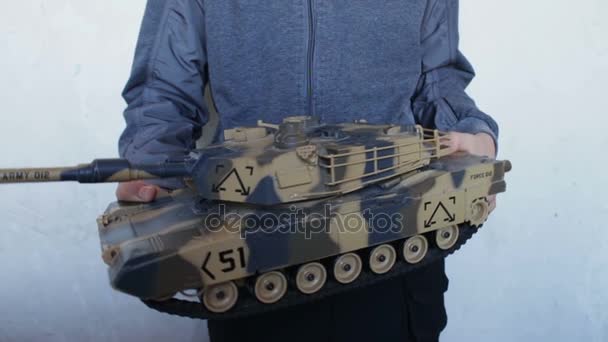 Child holding a big toy tank in the hands — Stock Video