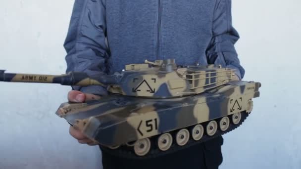 Child holding a big toy tank in the hands — Stock Video