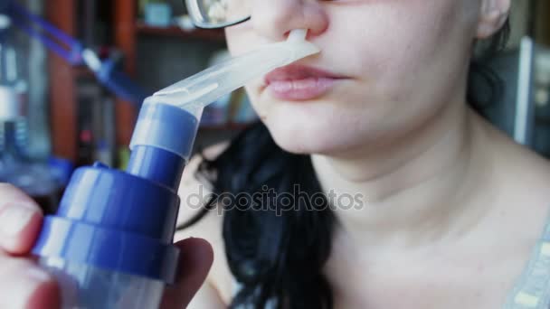 女の子は辛抱強く、吸入器を介して蒸気を呼吸します。 — ストック動画