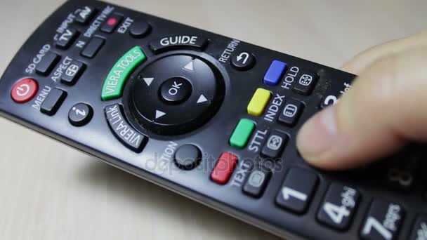 La mano humana cambia los canales en el control remoto de la TV — Vídeo de stock