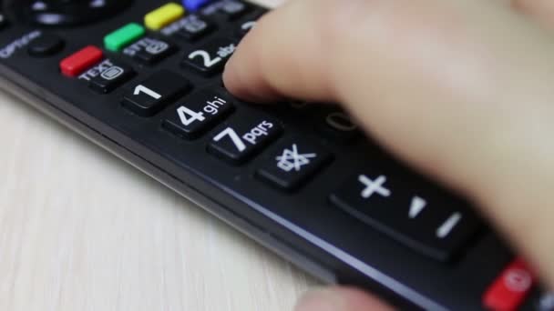Menselijke hand Hiermee wijzigt u de kanalen op de tv remote control — Stockvideo