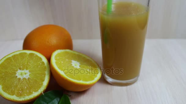 Sumo de laranja em um copo e frutas frescas em fundo de madeira — Vídeo de Stock