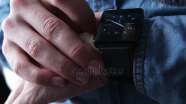 Genç adam akıllı bir saat kullanarak