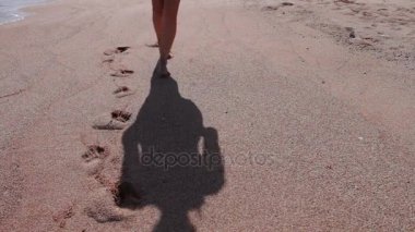 kız ayakları ayak izleri sahilde bırakın.